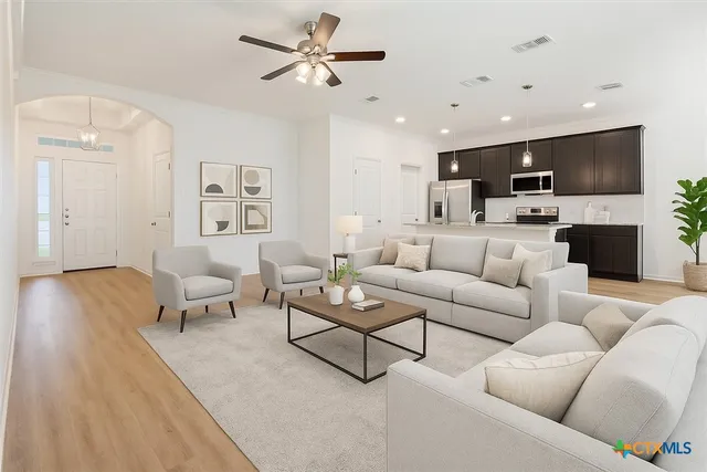 a living room with furniture a flat screen tv and a fireplace