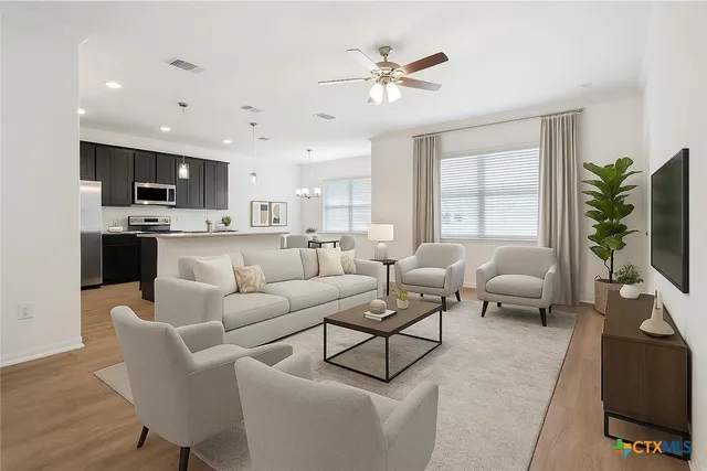 a living room with furniture kitchen view and a flat screen tv