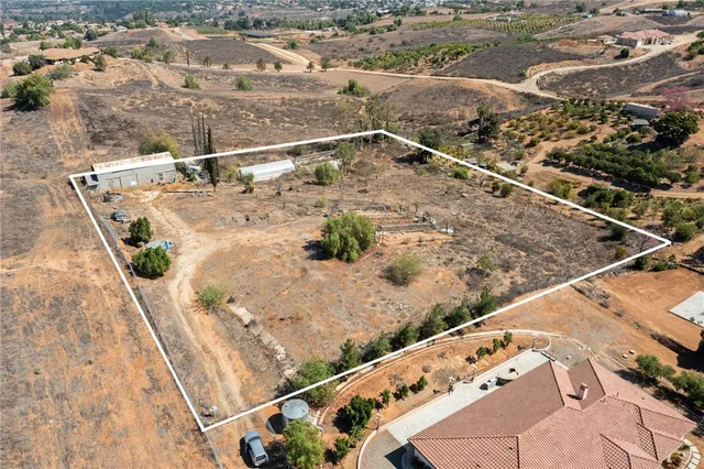 an aerial view of residential houses with outdoor space and ocean view