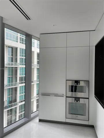 an empty room with floor to ceiling windows and walls