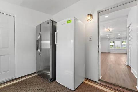 a view of a hallway with wooden floor and cabinet