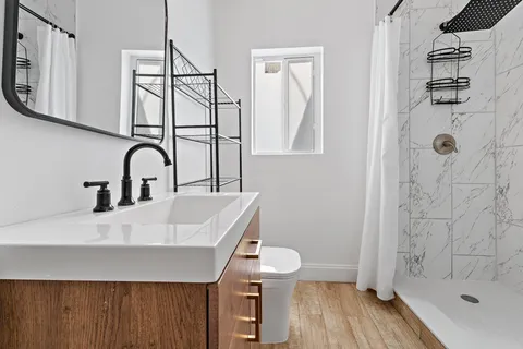 a bathroom with a sink a toilet and shower