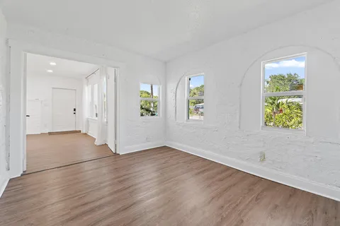 an empty room with windows and wooden floor