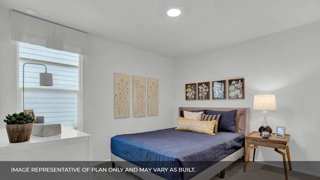 a bedroom with a bed and a potted plant on table