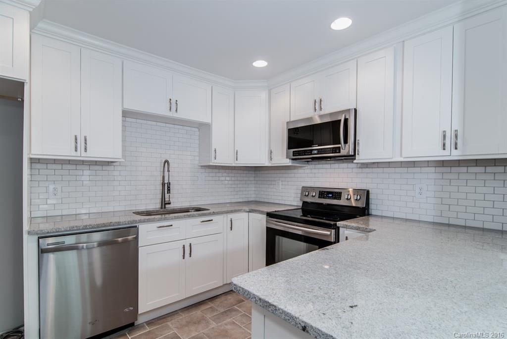 83 Ridgeport Road, Unit 83B Lake Wylie, SC 29710 - Photo 1 of 24 a kitchen with granite countertop white cabinets sink and stainless steel appliances