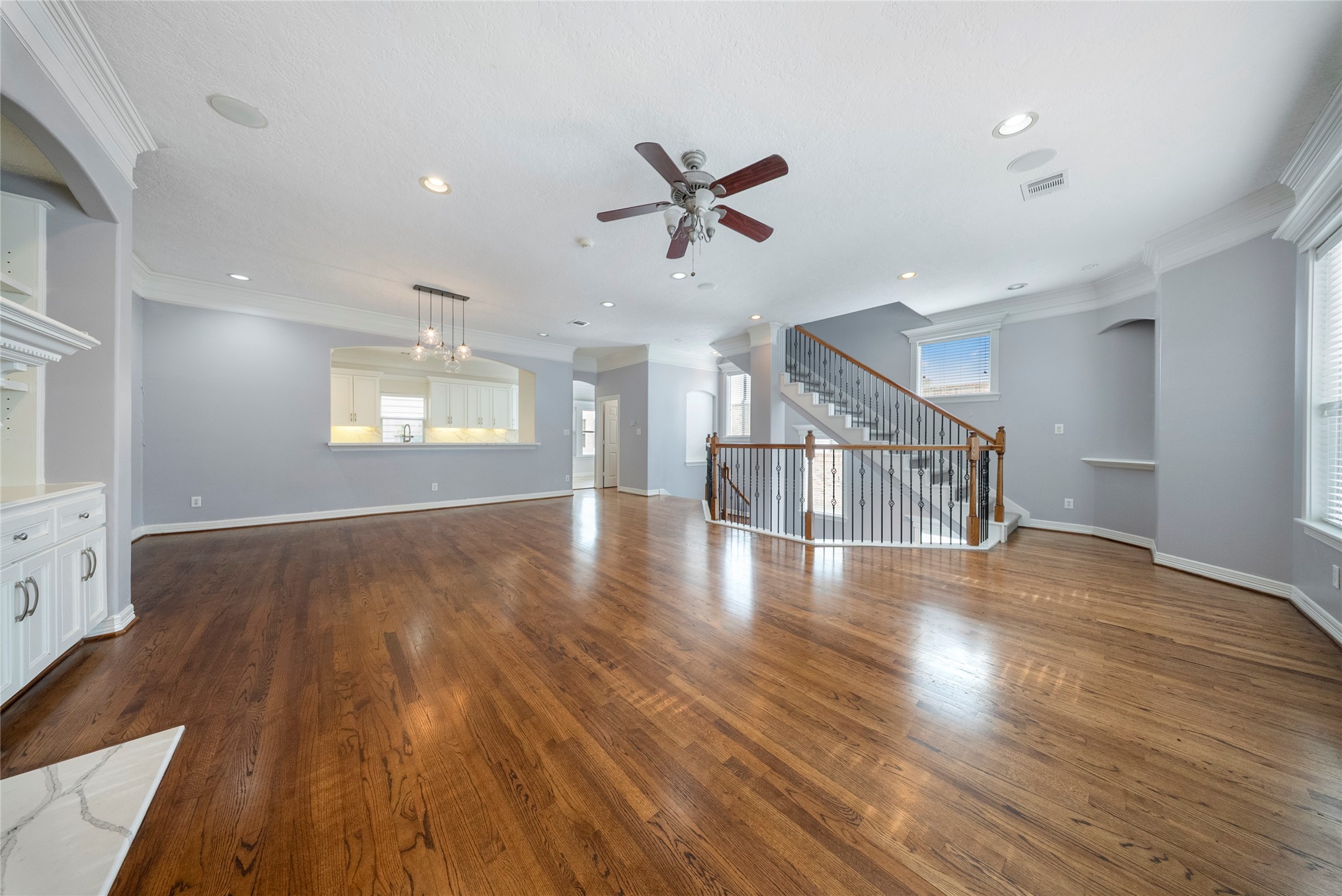 4216 Eli Street Houston, TX 77007 - Photo 4 of 25 an empty room with wooden floor windows and ceiling fan