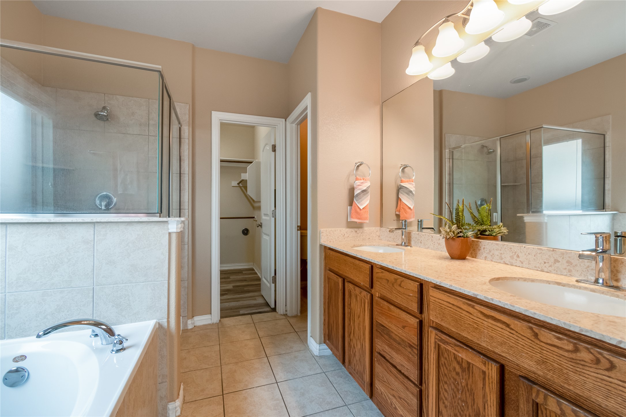 3413 Grail Hollows Road Pflugerville, TX 78660 - Photo 17 of 36 Full bathroom with a spacious closet, light tile patterned flooring, double vanity, a bath, and a shower stall