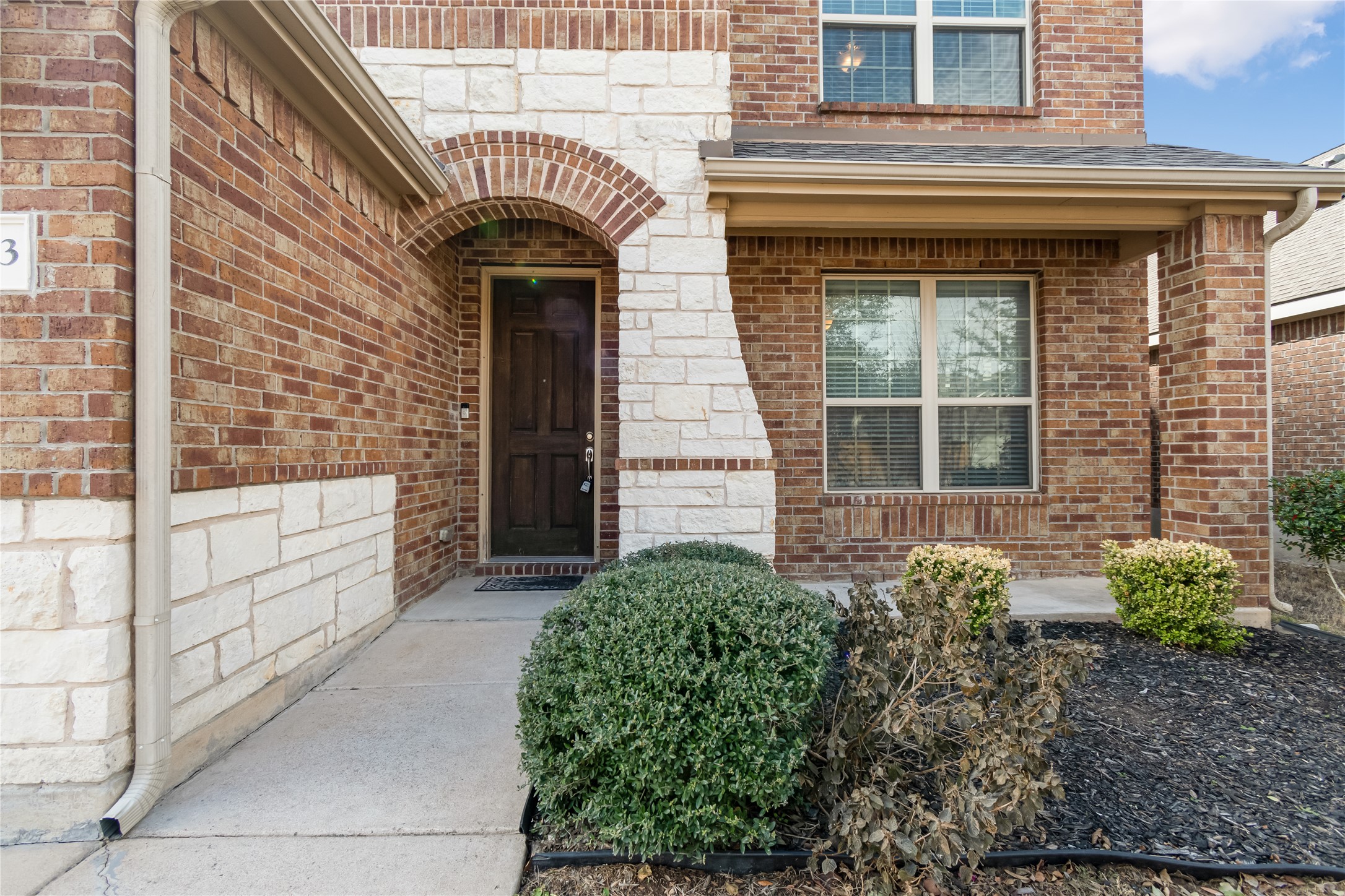 3413 Grail Hollows Road Pflugerville, TX 78660 - Photo 2 of 36 Doorway to property featuring brick siding, stone siding, and a shingled roof
