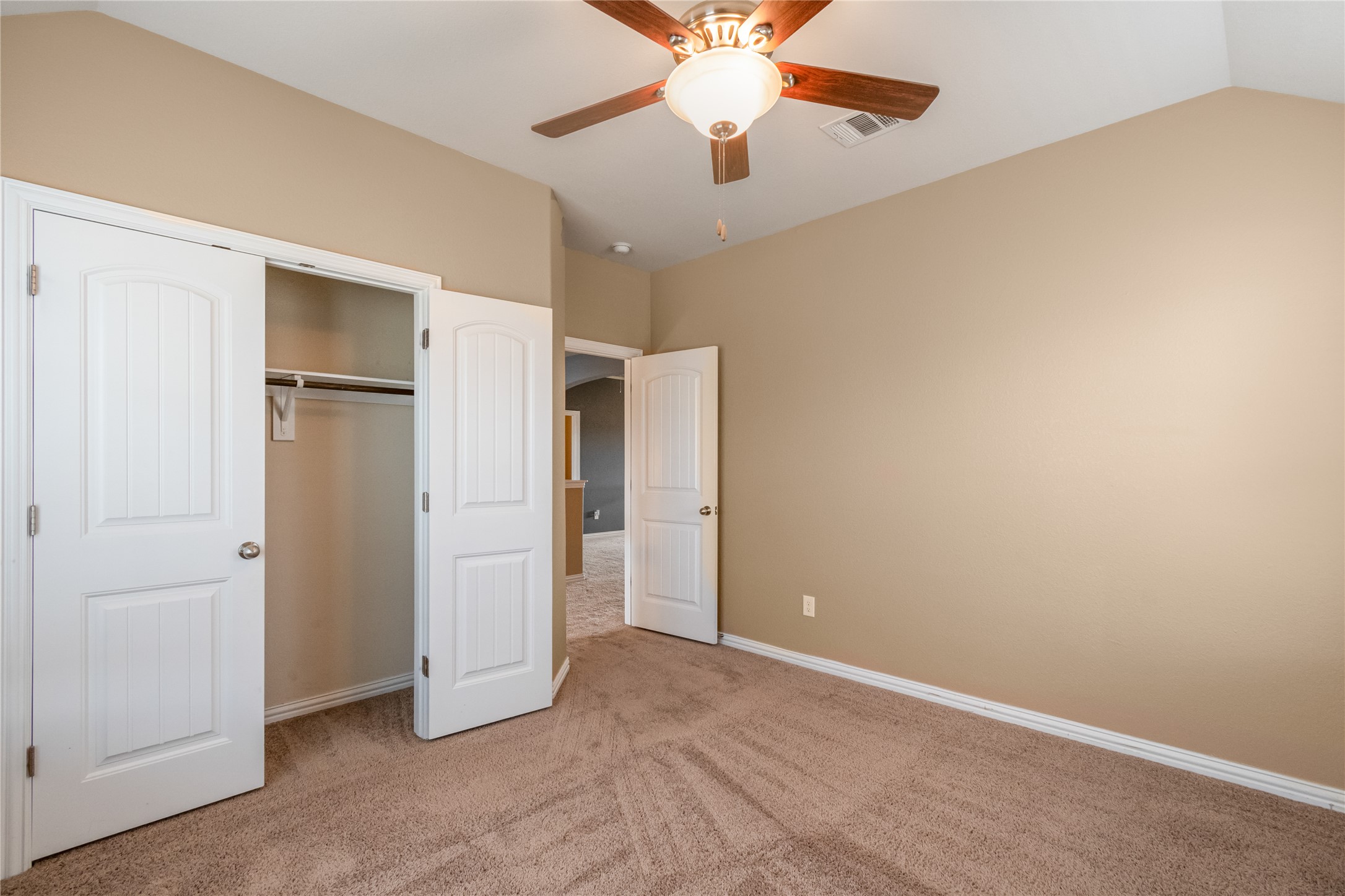 3413 Grail Hollows Road Pflugerville, TX 78660 - Photo 27 of 36 Unfurnished bedroom featuring light carpet, lofted ceiling, a ceiling fan, and a closet