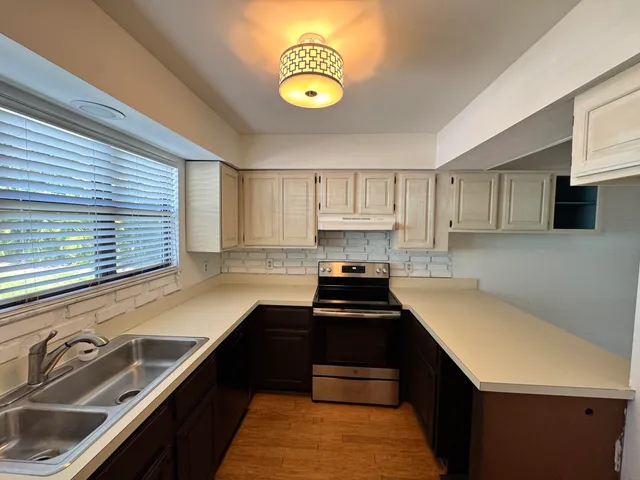 a kitchen with a sink a stove and cabinets