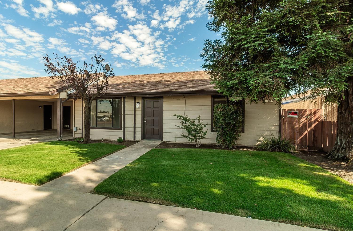 1306 13th Street Reedley, CA 93654 - Photo 3 of 14 a front view of a house with a garden