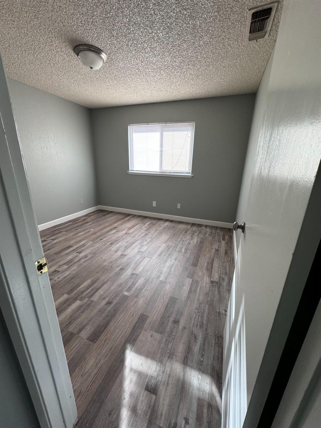 1306 13th Street Reedley, CA 93654 - Photo 7 of 14 a view of empty room with window