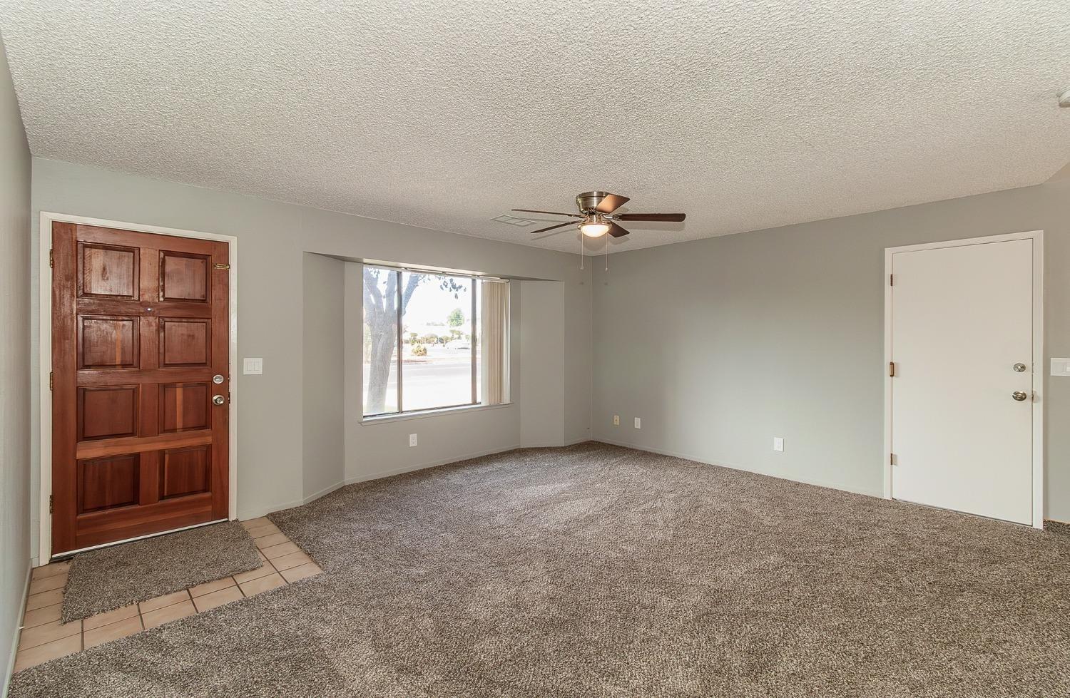 1306 13th Street Reedley, CA 93654 - Photo 9 of 14 a view of an empty room with closet and chandelier fan