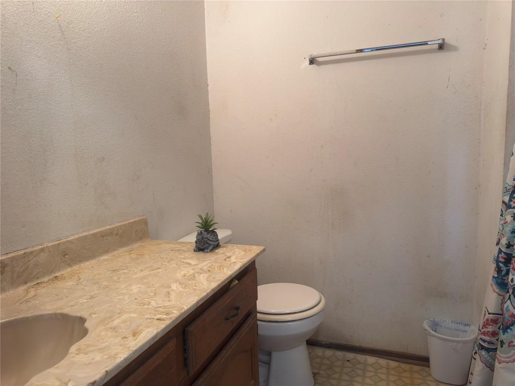 12776 Valverde Loop Terrell, TX 75161 - Photo 17 of 36 a bathroom with a granite countertop toilet and a sink