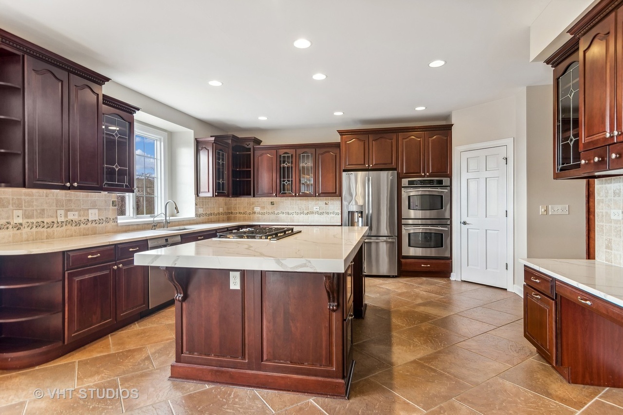 22206 North Prairie Lane Kildeer, IL 60047 - Photo 7 of 34 a kitchen with stainless steel appliances kitchen island granite countertop a stove refrigerator and cabinets