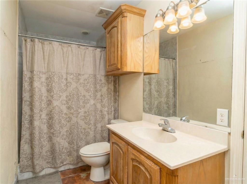 4706 North Trosper Road Mission, TX 78573 - Photo 2 of 12 a bathroom with a sink a toilet and shower curtain