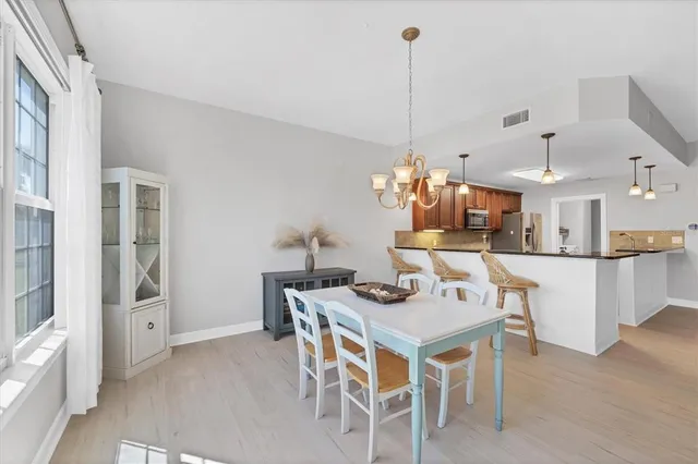 a dining room with furniture a chandelier and window