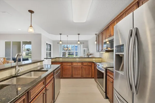 a kitchen with stainless steel appliances granite countertop a sink stove and refrigerator