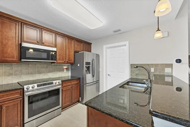a kitchen with stainless steel appliances granite countertop a sink and cabinets