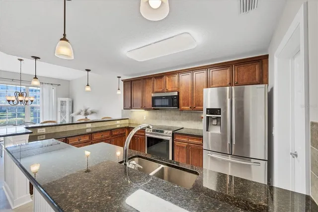 a kitchen with stainless steel appliances granite countertop a refrigerator stove and microwave