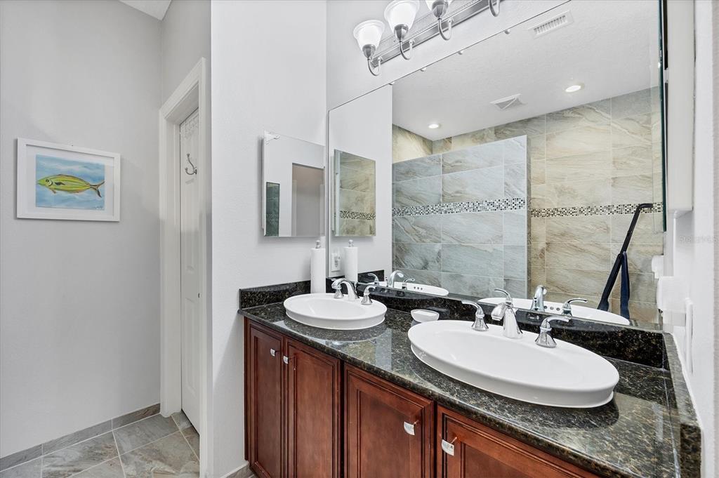 10720 Lemon Creek Loop, Unit 103 Englewood, FL 34224 - Photo 31 of 57 a bathroom with a double vanity sink and a mirror