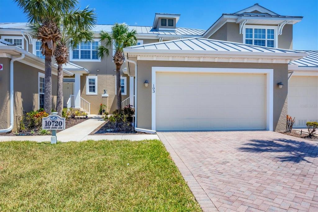 10720 Lemon Creek Loop, Unit 103 Englewood, FL 34224 - Photo 4 of 57 a front view of a house with a yard