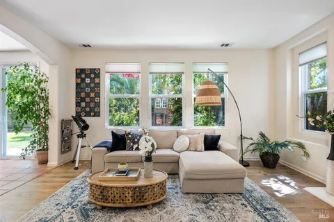 a living room with furniture fireplace and large windows