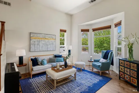 a living room with furniture a rug a lamp and a window