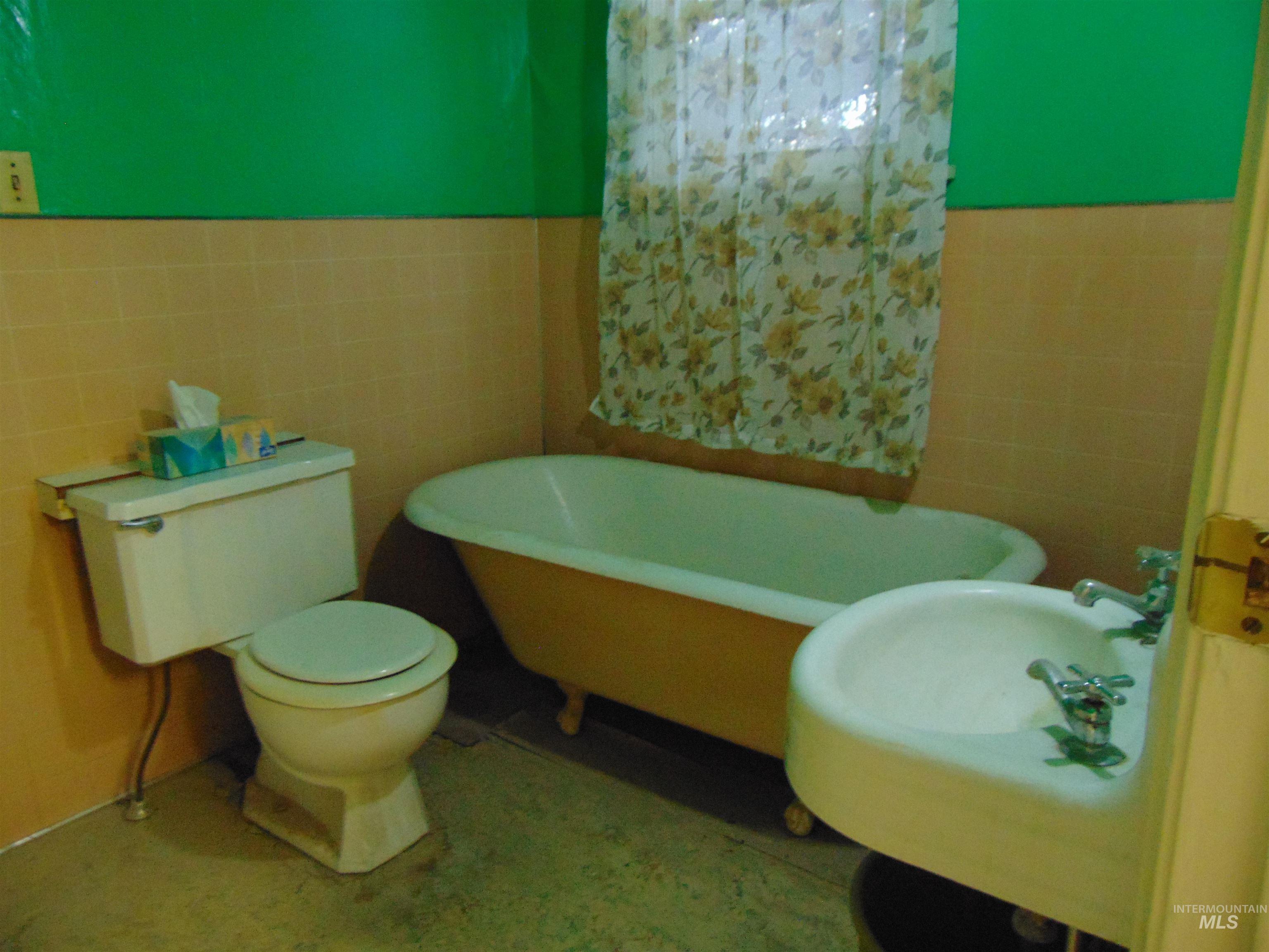 233 Glenn Street South Vale, OR 97918 - Photo 6 of 10 Full bath with tile walls, a freestanding bath, and a wainscoted wall