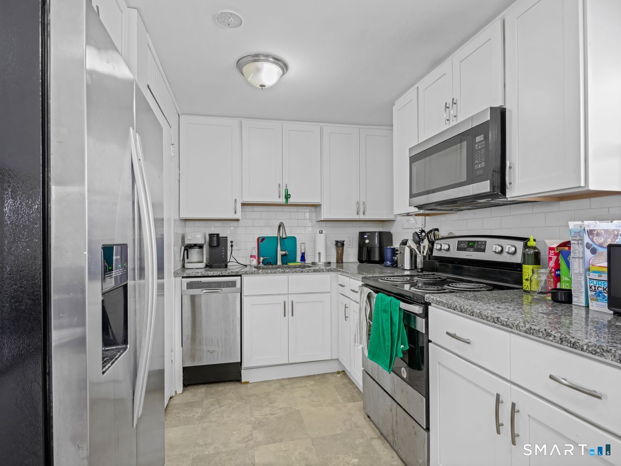 69 Seaver Circle Bridgeport, CT 06606 - Photo 16 of 29 a kitchen with stainless steel appliances granite countertop a refrigerator sink stove and white cabinets