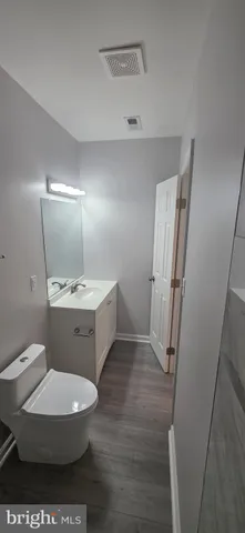 a bathroom with a sink a toilet a mirror and vanity