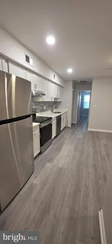 a kitchen with stainless steel appliances granite countertop a refrigerator a sink and a stove