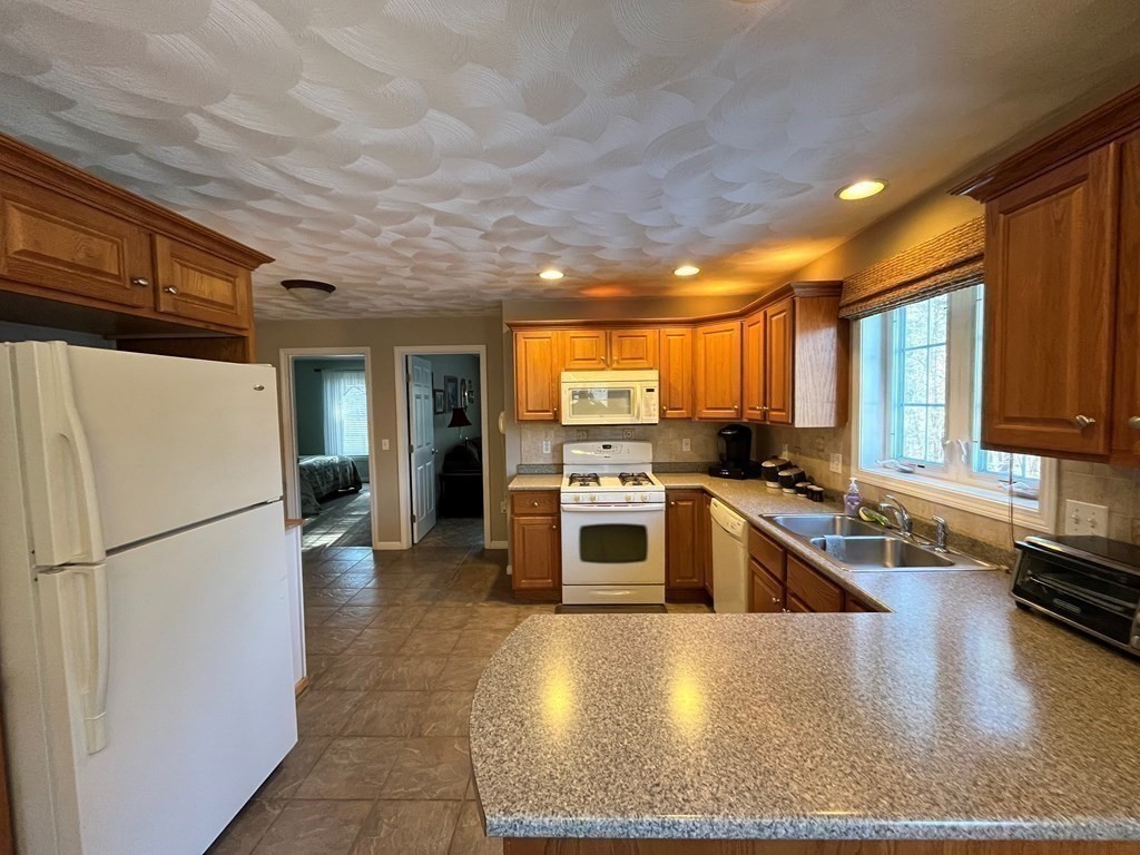 9 Flat Rock Road, Unit 9 Windham, NH 03087 - Photo 14 of 32 a kitchen with a refrigerator a stove top oven and a sink
