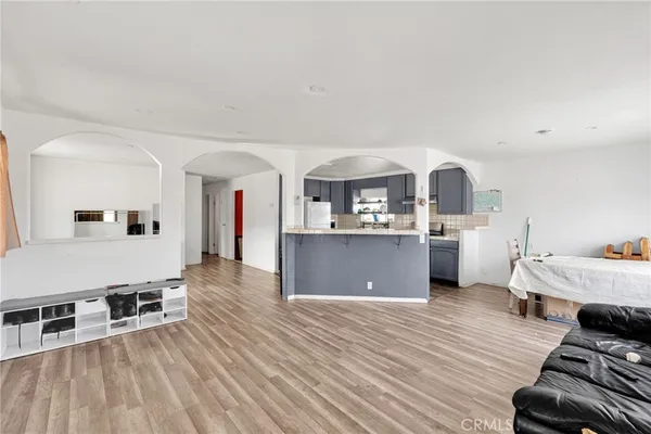 a kitchen with stainless steel appliances kitchen island wooden floors and white cabinets