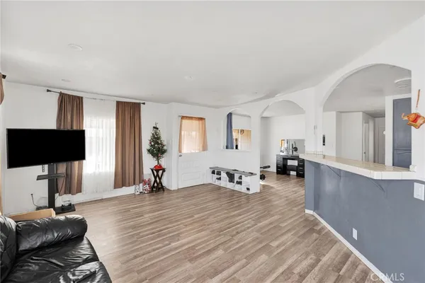 a living room with furniture a wooden floor and a flat screen tv