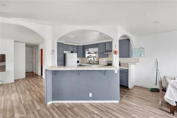 a kitchen with stainless steel appliances granite countertop a sink cabinets and wooden floor