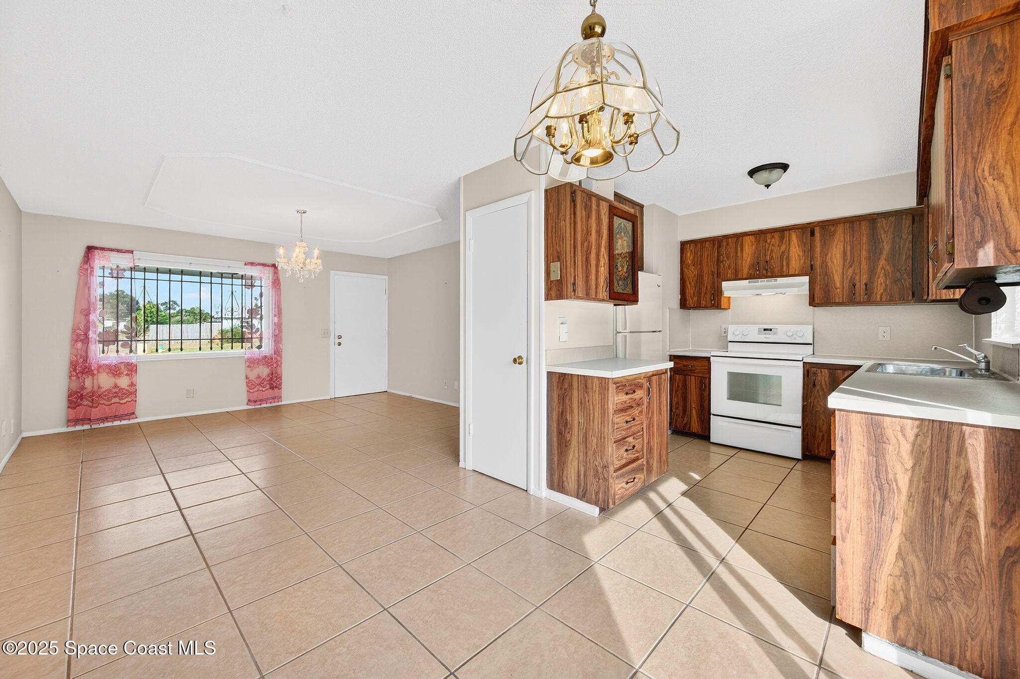 2135 Otterbein Avenue Cocoa, FL 32926 - Photo 11 of 28 a kitchen with stainless steel appliances a white refrigerator oven a sink dishwasher and white cabinets next to a window