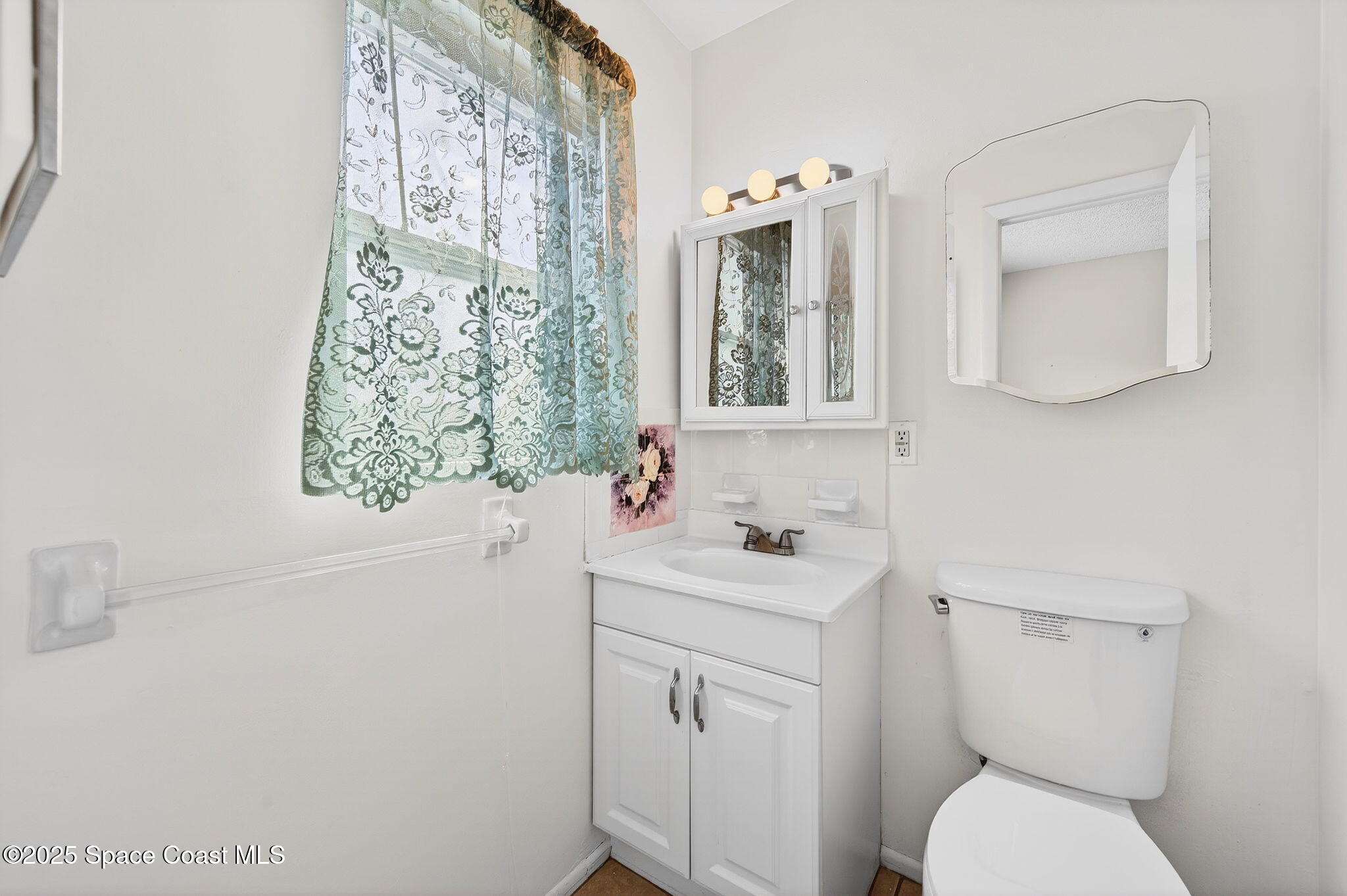 2135 Otterbein Avenue Cocoa, FL 32926 - Photo 18 of 28 a bathroom with a toilet sink and mirror