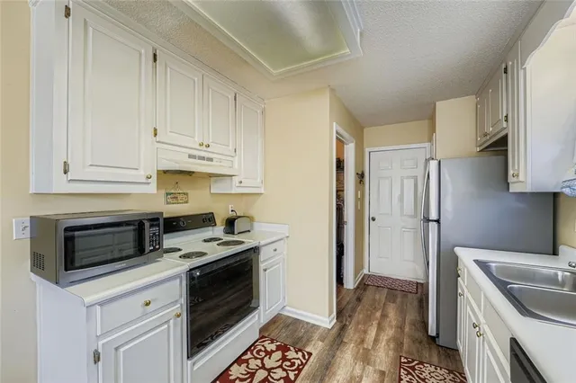 a kitchen with stainless steel appliances granite countertop a stove a refrigerator and a microwave