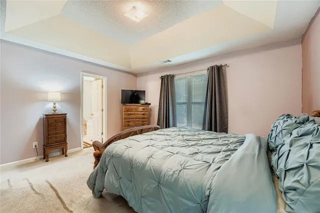 a spacious bedroom with a bed and a refrigerator