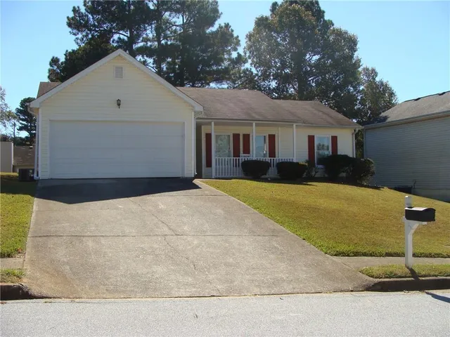 a view of a house with a yard and large tree