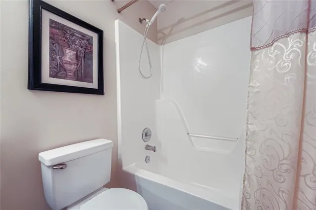 a white toilet sitting next to a bath tub shower
