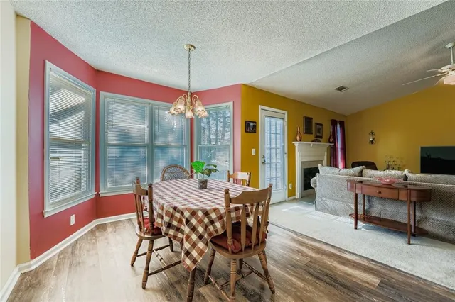 a dining room with furniture a chandelier and wooden floor