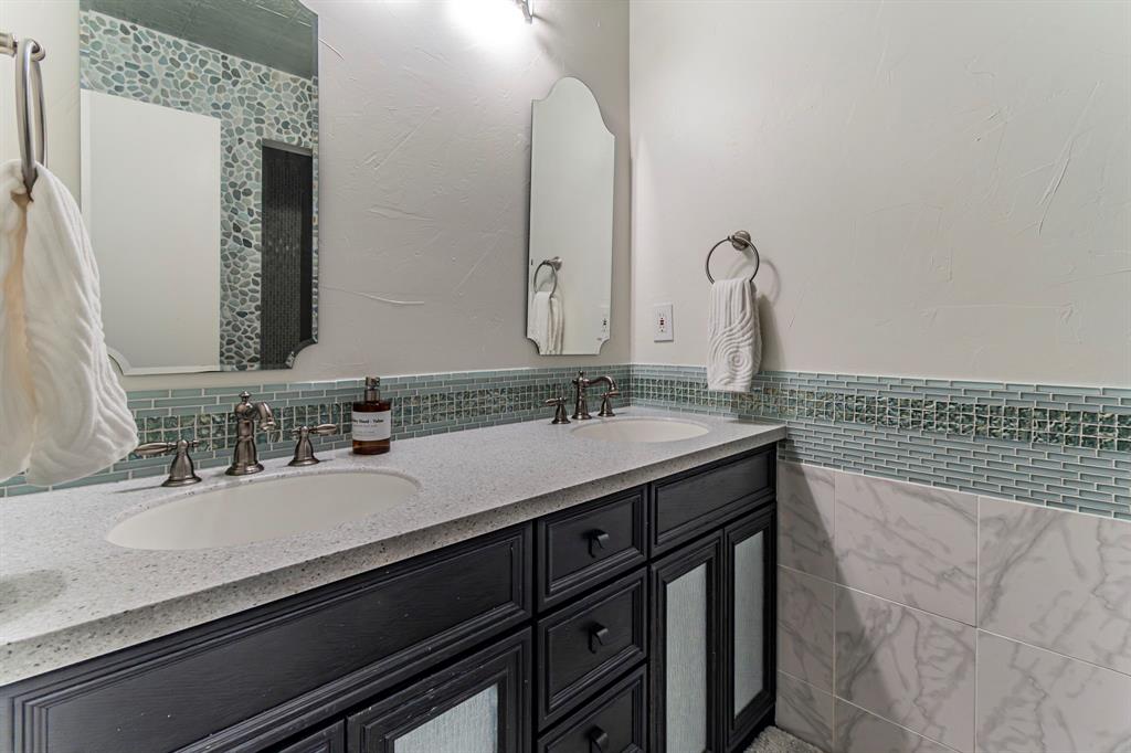127 Nicklaus Nook Lancaster, TX 75146 - Photo 24 of 37 Full bathroom featuring double vanity, tile walls, and wainscoting
