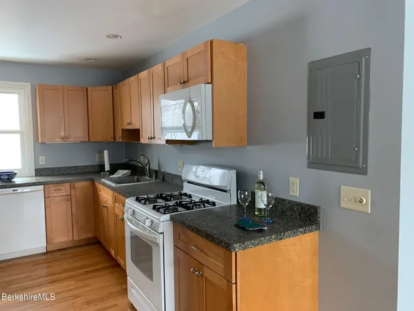 a kitchen with stainless steel appliances granite countertop a stove a sink and a microwave