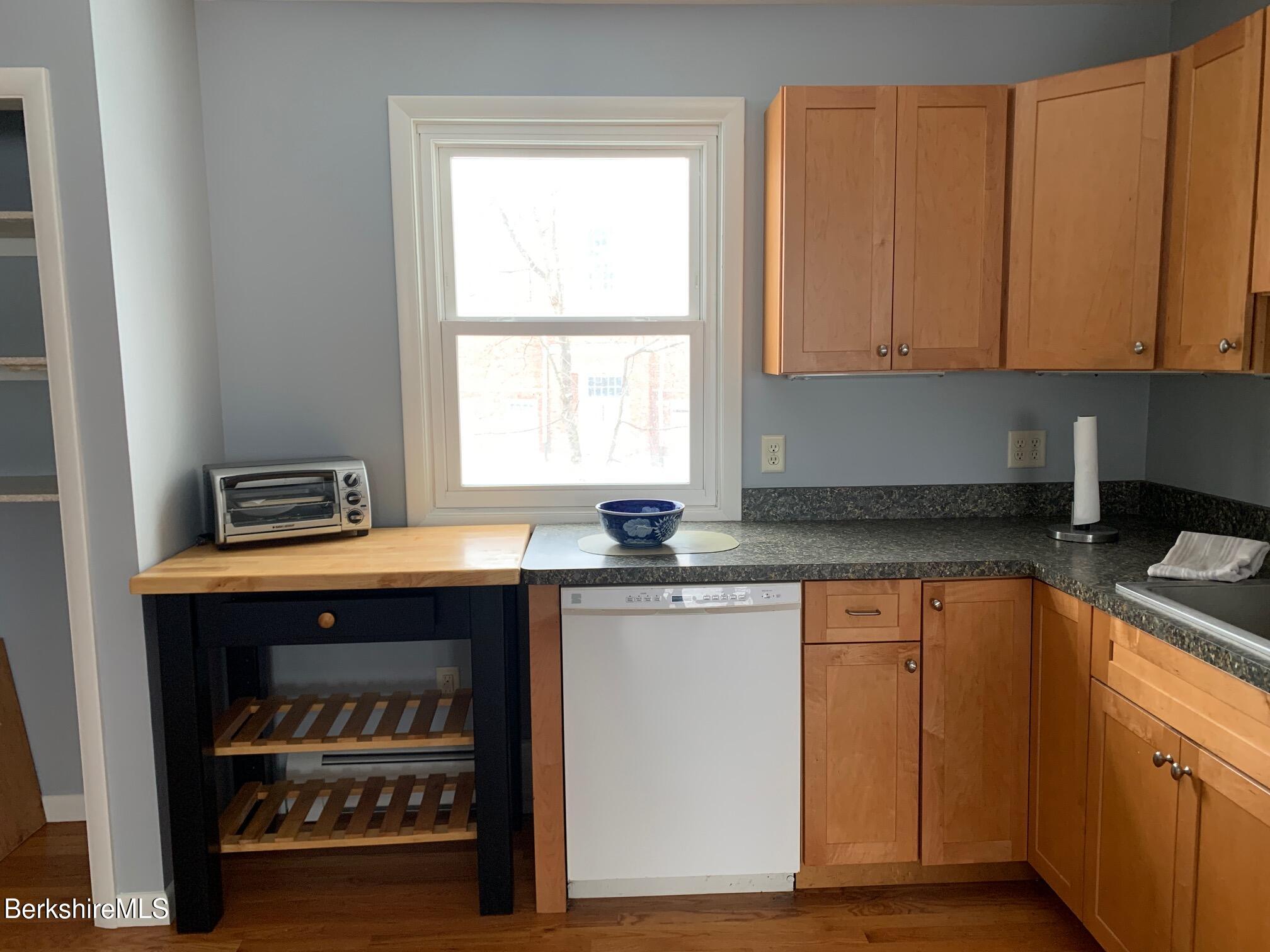 4 Morgan Manor, Unit 4 Lenox, MA 01240 - Photo 10 of 15 a kitchen with granite countertop a stove a sink and dishwasher with wooden floor