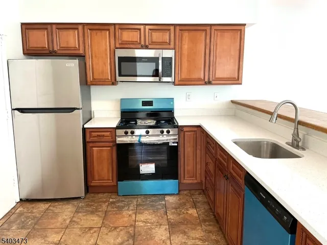 a kitchen with stainless steel appliances a refrigerator stove and microwave