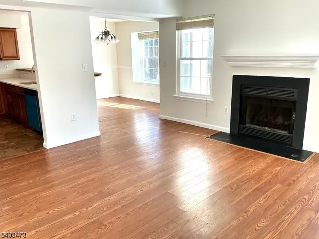 a view of a livingroom with wooden floor and a fireplace