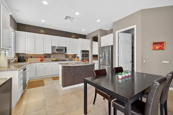 a kitchen with granite countertop white cabinets and white appliances