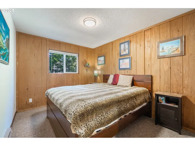a bedroom with a bed and a flat tv screen on dresser